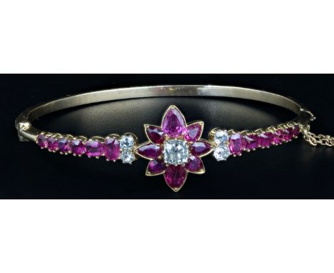 A ruby and diamond half hoop bangle, with central cluster of old cushion cut diamonds, within a border of graduated pear-shap