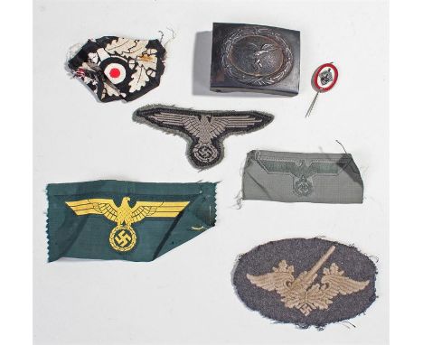 German Second World War militaria, to include a belt buckle with an eagle above a swastika belt buckle, five cloth badges and