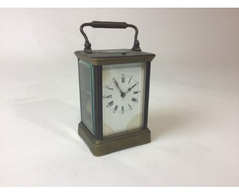 A gilt brass carriage clock with visible movement striking on a coiled gong. H:12.5cm