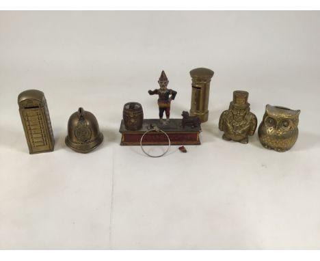 A vintage money box with interactive dog and clown, together with five brass money boxes. 