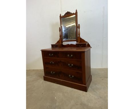 A stained pine dressing chest with four lower drawers bevelled mirror and vanity drawers to top section.W:110cm x D:51cm x H:
