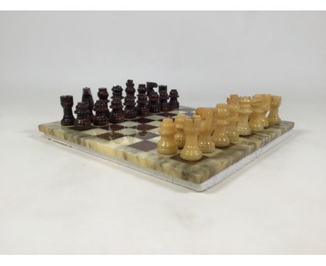 An alabaster chess board and pieces, complete, with a backgammon board and pieces in a suede case.