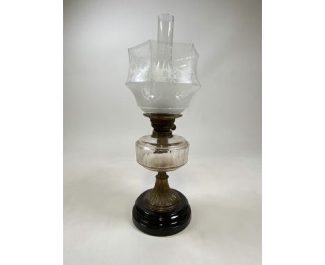 A Victorian oil lamp with etched glass shade.