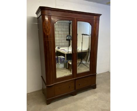 An Edwardian inlaid double wardrobe with bevelled mirror glass and bow fronted panel sides. Separate cornice and base with tw