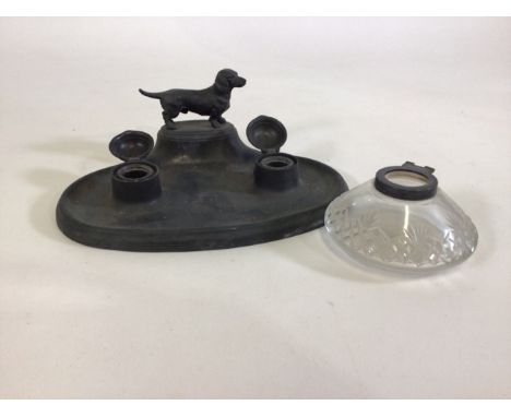 A pewter inkwell with dachshund and a white metal topped inkwell. 