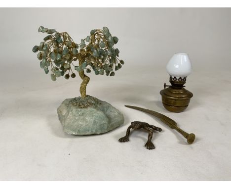 A green adventuring stone tree together will a small brass lamp, brass frog and a brass quill.