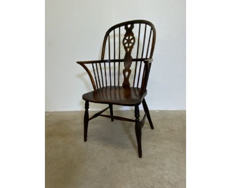 A 18th century Elm windsor wheel and stick back arm chair. W:58cm x D:46cm x H:101cm