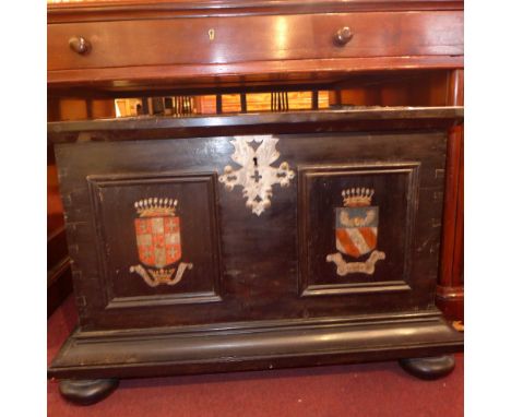 SOLD IN TIMED AUCTION A black painted and metal bound trunk with painted armorial crest detail 