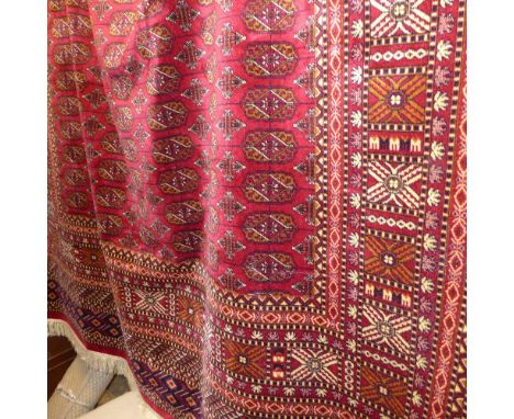 SOLD IN TIMED AUCTION A Bokhara style carpet with many guls on a red field, surrounded by many borders 280 x 200 