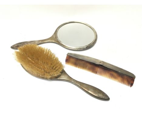 A silver hallmarked hand mirror, brush and comb.