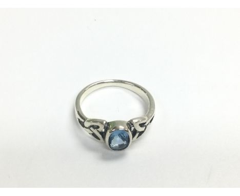 A silver Celtic style ring set with a light blue CZ, approx size L. Shipping category A.