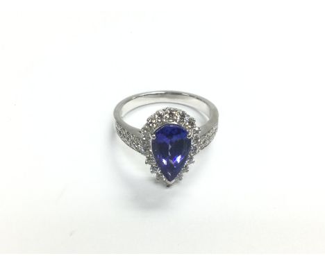 A certificated 18ct white gold dress ring set with mixed pear cut tanzanite and RBC diamond halo and shoulders. Tanzanite app