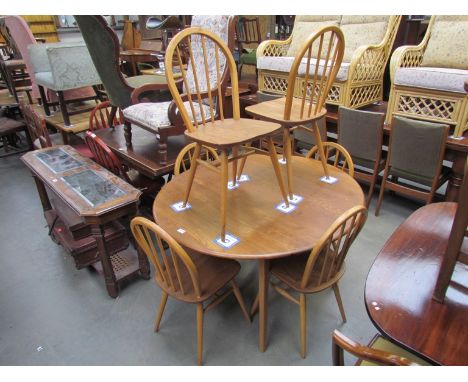 An Ercol light elm and beech drop-leaf kitchen table with six stick-back chairs