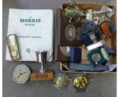 A collection of motoring trophies and medals, AA badges, Morris Minor workshop manual, car clock, etc.