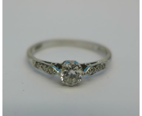 An 18ct gold, diamond solitaire ring with diamond shoulders, 2.4g, R