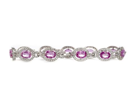 PINK SAPPHIRE AND DIAMOND BRACELET, set with oval pink sapphires totalling approximately 10.15 carats, within diamond halos, 