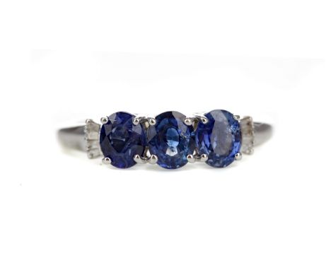 SAPPHIRE AND DIAMOND RING, set with three oval sapphires flanked by tapered baguette cut diamonds totalling approximately 0.1