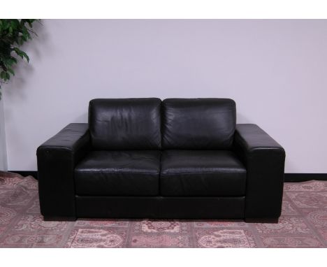 A modern black leather two seater sofa by Natuzzi, 172cm wide, 95cm deep, having fixed cushions