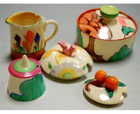 Assorted Clarice Cliff wares to include Fantasque, Bizarre preserve pot cover, one other, Crocus cream jug, and two preserve 