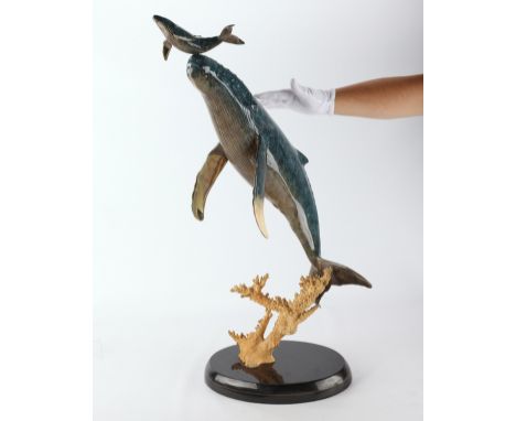 Robert Wyland (American, b. 1956). Polychrome bronze sculpture depicting a whale supporting a young whale on its nose. Signed