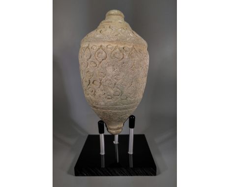 Ca.800 AD. A hollow ceramic vessel with barrel-shaped body, domed top and conical base, the body with geometric motifs; knop 