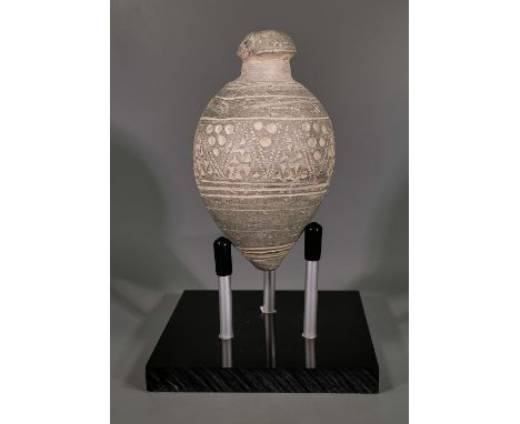 Ca.800 AD. A hollow ceramic vessel with barrel-shaped body, domed top and conical base, the body with a circular and triangul