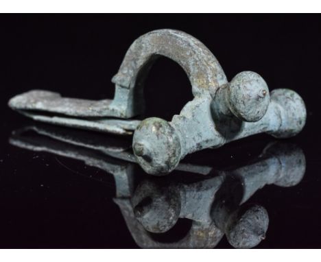 Ca.400 AD. A Roman Legionary cast crossbow brooch with transverse arm and three onion terminals, socketed to the forward face