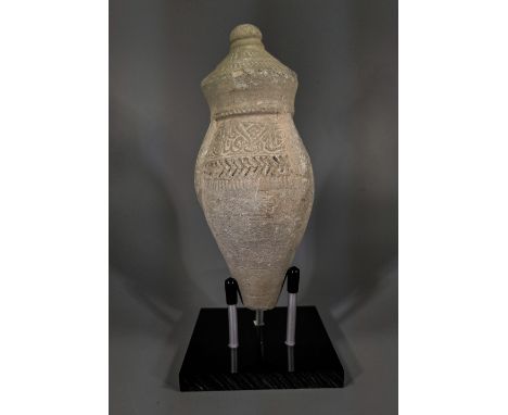Ca.800 AD. A hollow ceramic vessel with barrel-shaped body, domed top and conical base, the body with a geometric design; kno