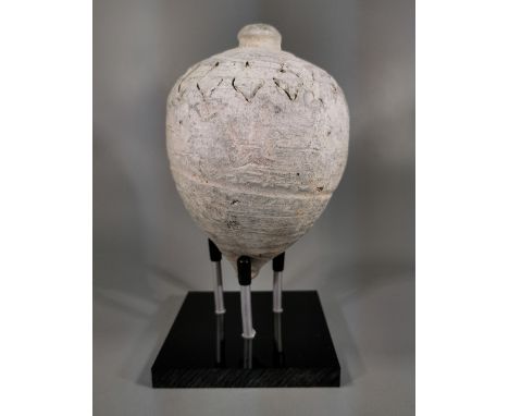 Ca.800 AD. A hollow ceramic vessel with barrel-shaped body, domed top and conical base, the body with a latticework design; k