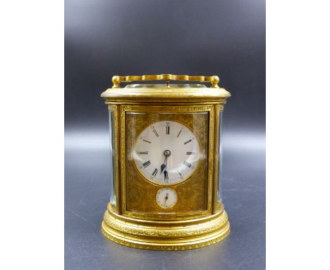 AN ALARM CARRIAGE CLOCK IN ENGRAVED OVAL SECTION CASE, THE HOUR AND HALF HOUR STRIKE / REPEAT ON A BELL.   H.12.5CMS.