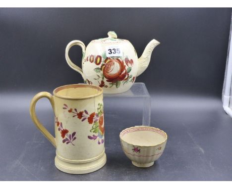 AN ANTIQUE CREAMWARE TEAPOT, TEA BOWL AND PINT MUG EACH PAINTED WITH COLOURED FLOWERS.