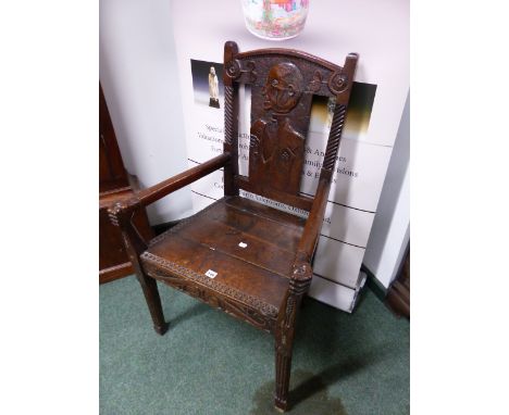 AN INTERESTING CARVED OAK RUSTIC ARMCHAIR, THE BACK DECORATED WITH A MAN'S PROFILE PORTRAIT. THE ARMS TERMINATING IN HAND HEL