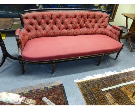 A 19TH.C.EBONISED AND GILT BUTTON BACK LOUIS XVI STYLE SALON SETTEE WITH BRASS CASTORS.   W.184CMS.