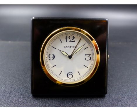 A CARTIER TRAVEL ALARM CLOCK, MODEL 0251 MOUNTED IN A BLACK LEATHER FOLDING TRAVEL CASE WITH A CARTIER MONOGRAM.  