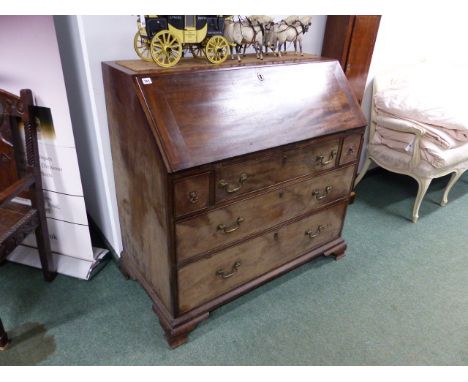 AN UNUSUAL GEORGIAN SLANT TOP BUREAU OF GENEROUS PROPORTIONS WITH FITTED INTERIOR OVER THREE ALIGNED AND TWO LONG DRAWERS ON 