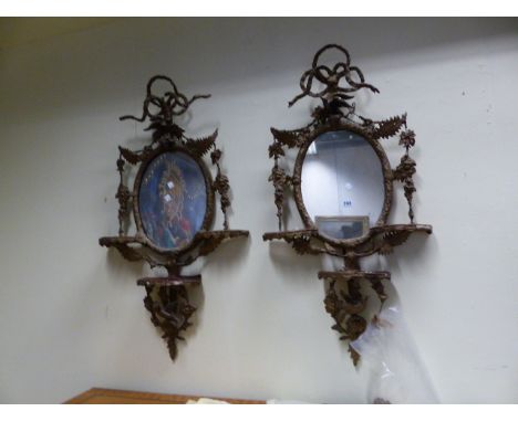 A PAIR OF VICTORIAN GILT OVAL WALL MIRRORS EACH WITH THREE SHELF BRACKETS AND DECORATED WITH BIRDS AND FOLIAGE.   H.100CMS.