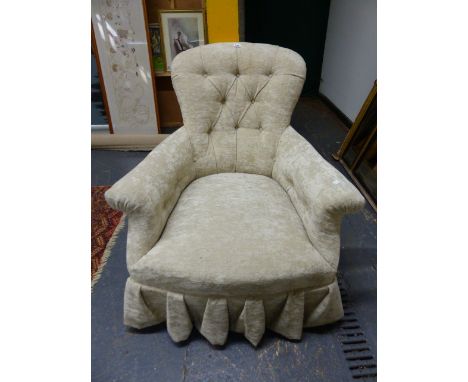A VICTORIAN BUTTON BACK SALON ARMCHAIR WITH TURNED LEGS THAT END IN BRASS AND CERAMIC CASTORS.