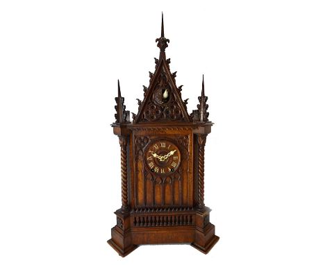 A Black Forest walnut cuckoo clock retailed by Camerer, Kuss & Co , late 19th century, of Gothic architectural form with inte