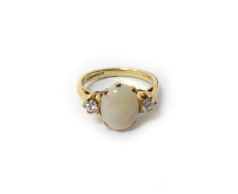 A 9ct gold, opal and diamond three stone ring, claw set with the oval opal at the centre, between two circular cut diamonds, 