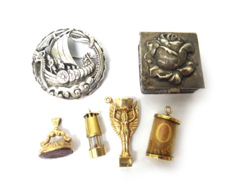 Four 9ct gold charms, comprising; The World Cup, a miner's lamp, a cornelain set seal and a ten shilling note, gross combined