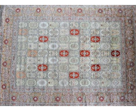 A Nepalese silk carpet, the field made up of compartments bearing arches and flowers, a wide 'gold' border with palmette and 