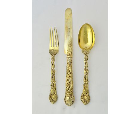 A Victorian silver gilt three piece christening set, comprising; a knife, having a loaded handle, a fork and a spoon, each de