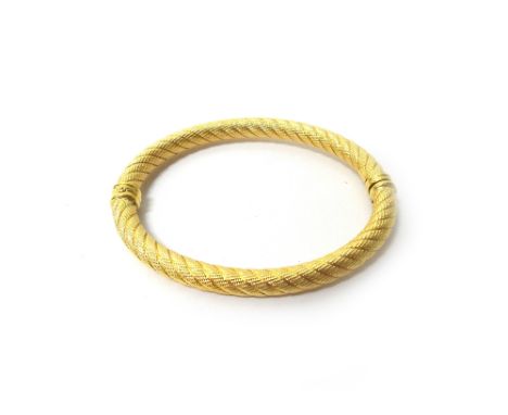 A gold oval hinged bangle, in a decorated ropetwist design, detailed 750, with a foldover safety catch, gross weight 13.6 gms