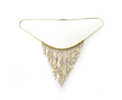 A two colour gold fringe necklace, the front in a beaded design, with graduated pendant chains, on a sprung hook shaped clasp
