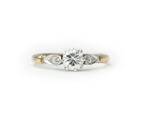A gold and platinum ring, claw set with the principal circular cut diamond at the centre, between diamond set single stone sh