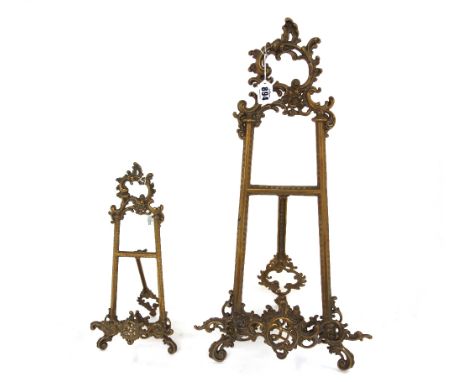 A gilt metal table easel of Rococo design, and another similar, 54cm high (2).  