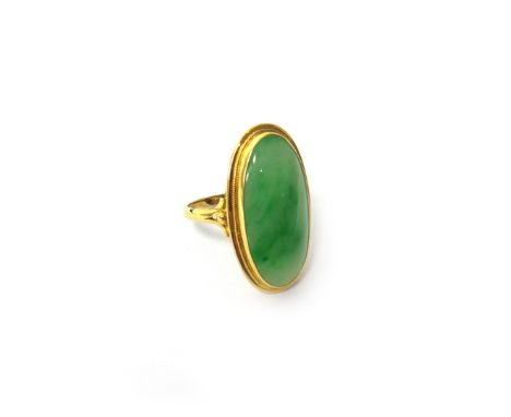 A gold ring, mounted with an oval jade, detailed 750, ring size V.