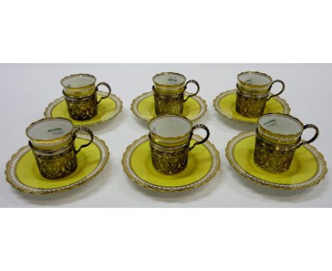 A set of six Aynsley porcelain coffee cups and saucers, each decorated in pale yellow and with gilt borders, with six silver 
