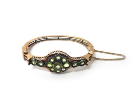 A Russian gold and peridot oval hinged bangle, in a split bar design, on a snap clasp, detailed 56 BA, bears Faberge mark.