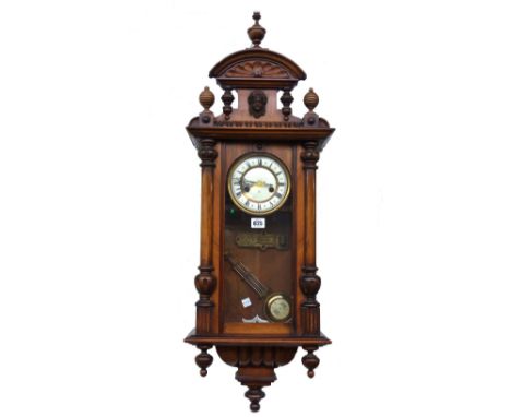 A walnut cased Vienna style wall clock, early 20th century, (95cm high) (pendulum & key) and an early 20th century oak cased 